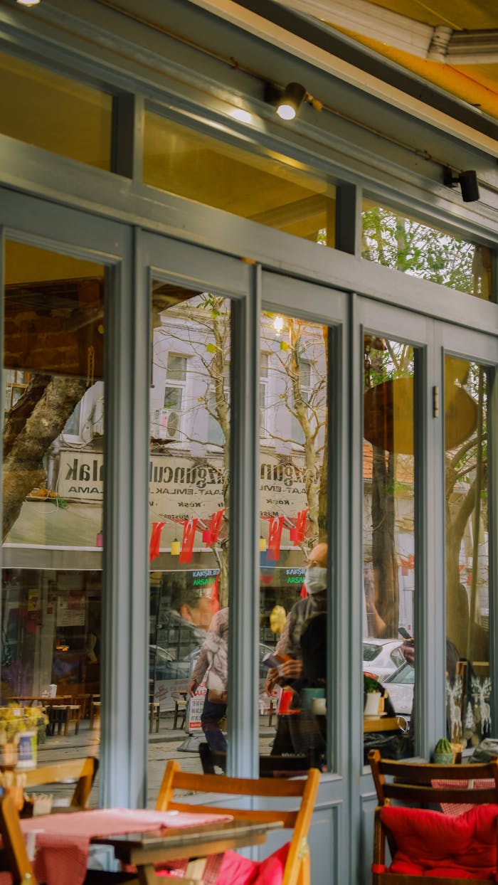 About Charming café scene reflecting vibrant street life with glass doors and seating.
